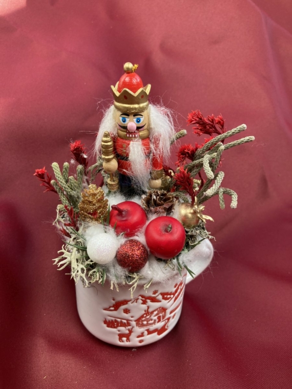 Diótörő Dániel piros sóvirággal ékített karácsonyi töltött bögrécskéje tartós virágdísz