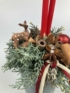 Kép 2/4 - Kíváncsiskodó őzikés, piros szalmagyertyás karácsonyi töltött bögre boróka ágyon, szalaggal