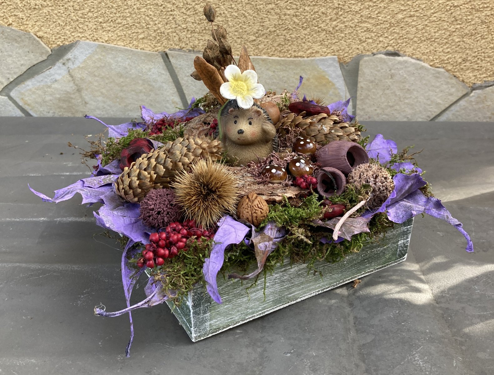 Süni találka - természetes alapanyagokkal díszített asztaldísz egy virág alatt rejtőző süni figurával